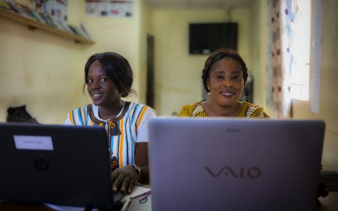 Jemiatu and Joanna from SLURC in Sierra Leone are shown sitting in front of laptops Credits Angus Stewart